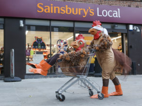 Person in a chicken suit sat in a trolly being pushed by another chicken wearing a blindfold, outside a Sainsbury’s © Matt Writtle 2016